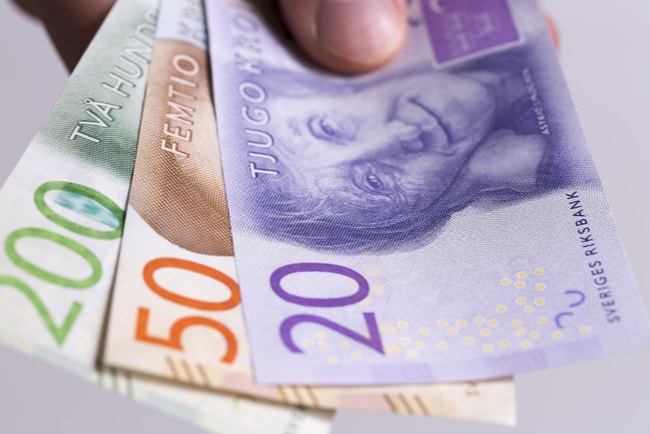 hand håller fram svenska sedlar